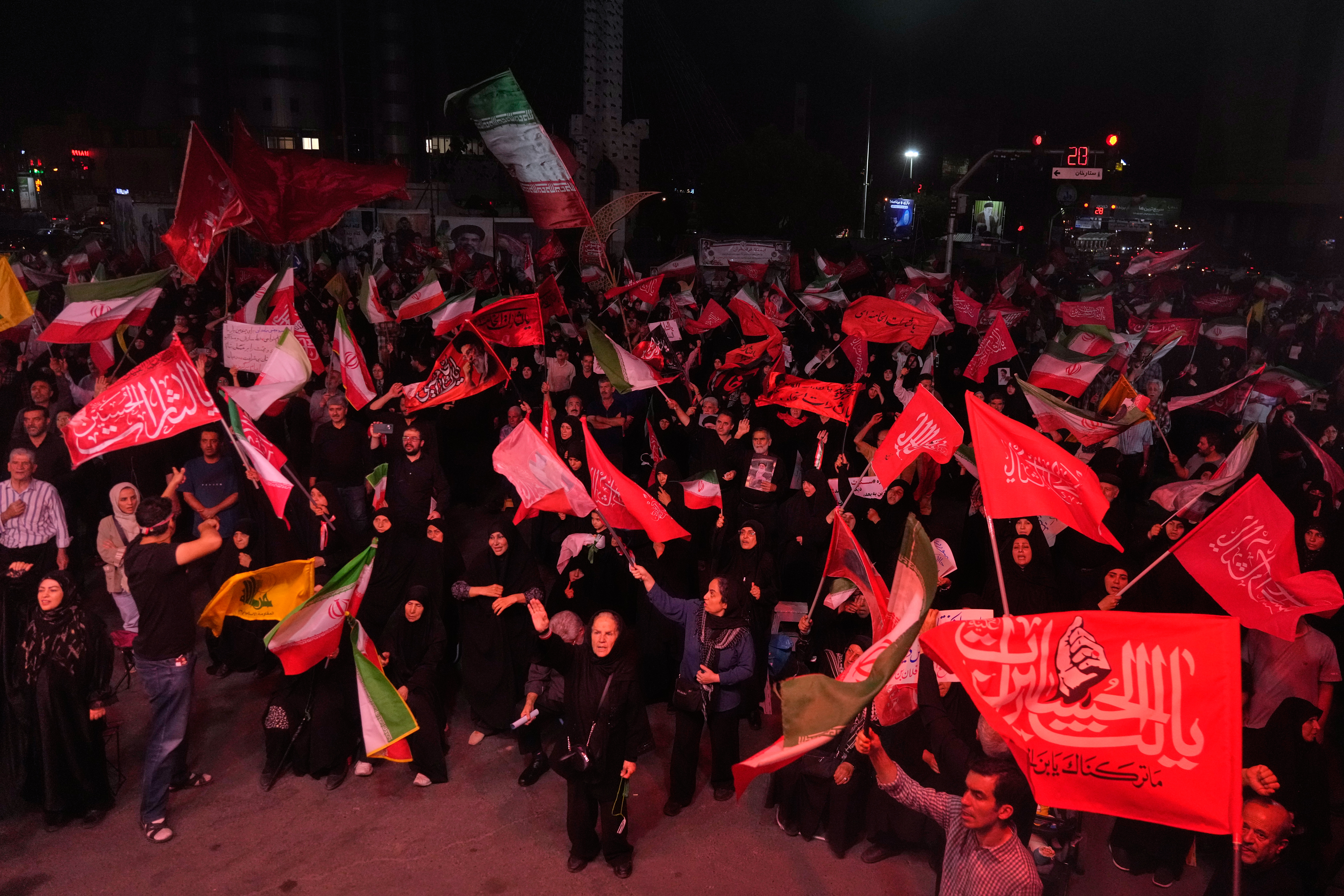 Pro-government demonstrators wave Iranian and religious flags in a gathering commemorating the late Iranian Supreme Leader Ayatollah Ali Khamenei at a square in Tehran.
