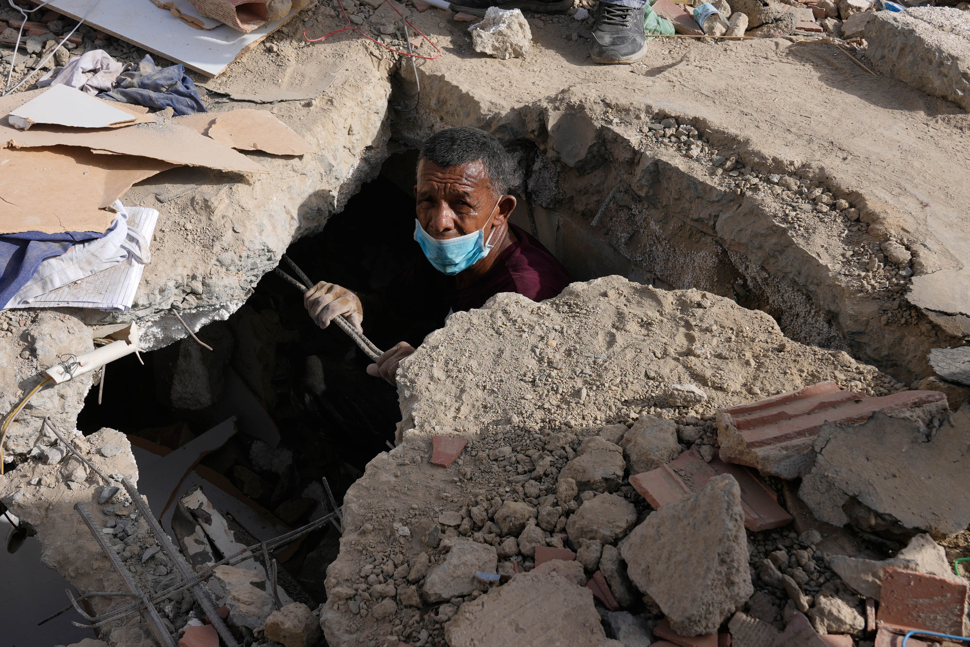 Franklin Fuentes searches for missing relatives in the collapsed building where they lived two days after earthquakes struck La Guaira, Venezuela, Friday, June 26, 2026.