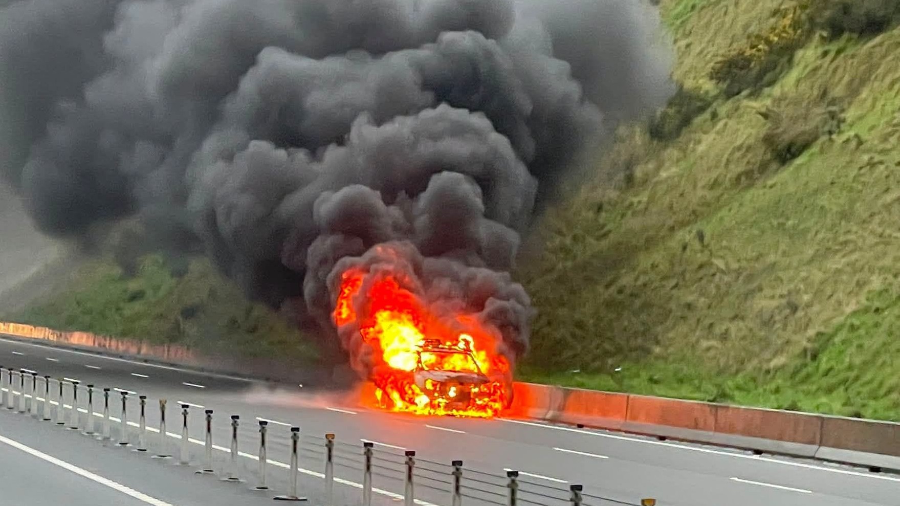 A vehicle burns on SH1 at Transmission Gully. (Source: The Traffic Fox)