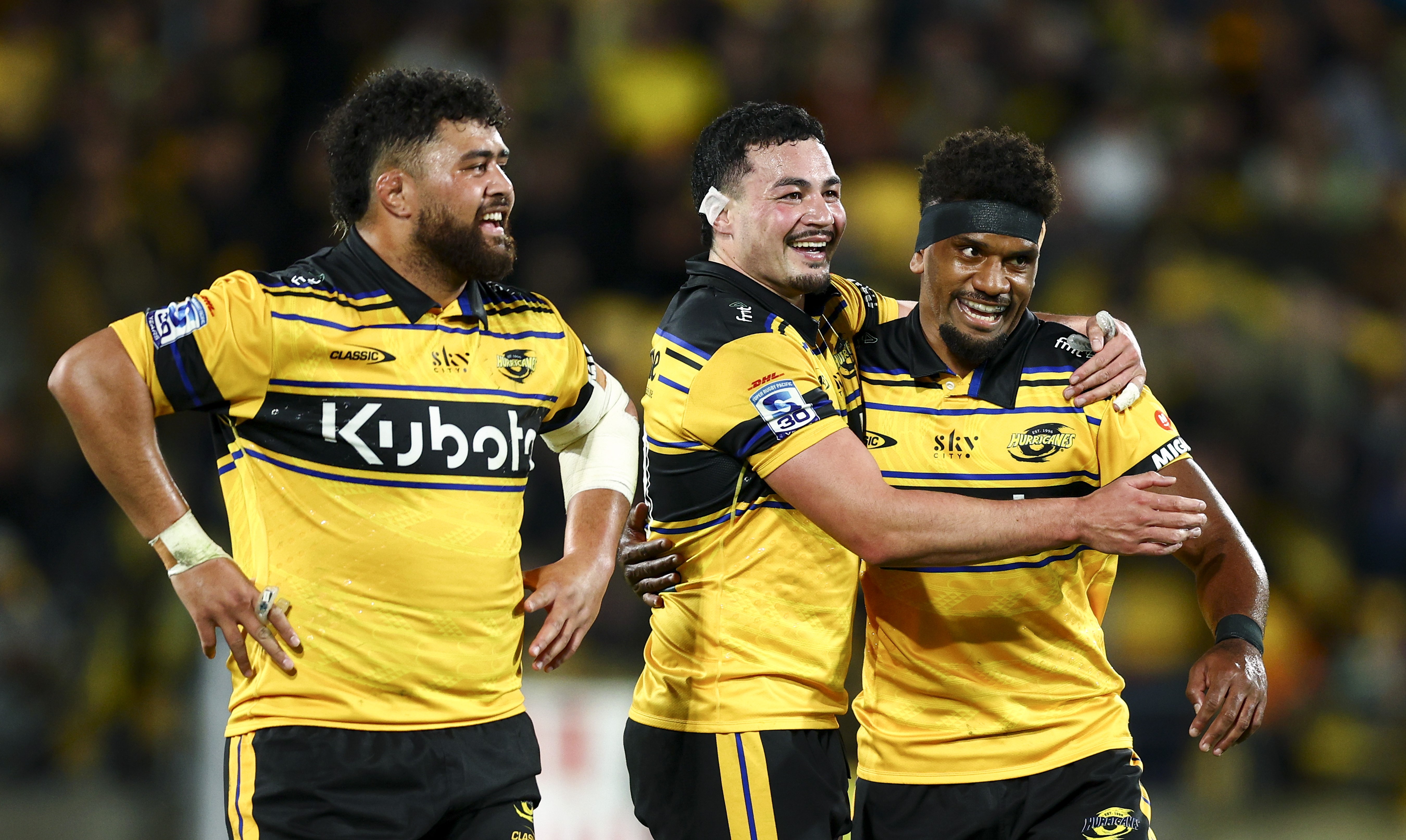 Siale Lauaki, left, Brayden Iose and Jone Rova celebrate the Hurricanes' semifinal win over the Blues.
