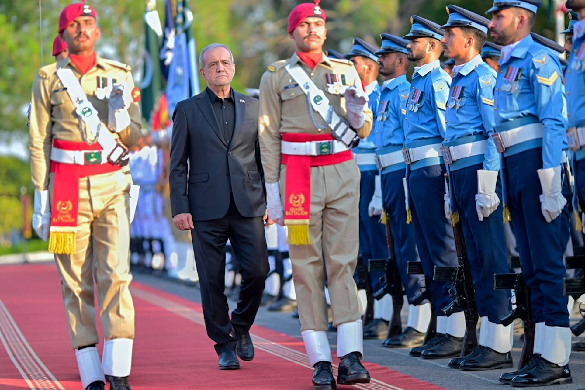 In this photo released by the Pakistan Prime Minister Office, Iran's President Masoud Pezeshkian, center, reviews an honor guard during a welcome ceremony in Islamabad, Pakistan