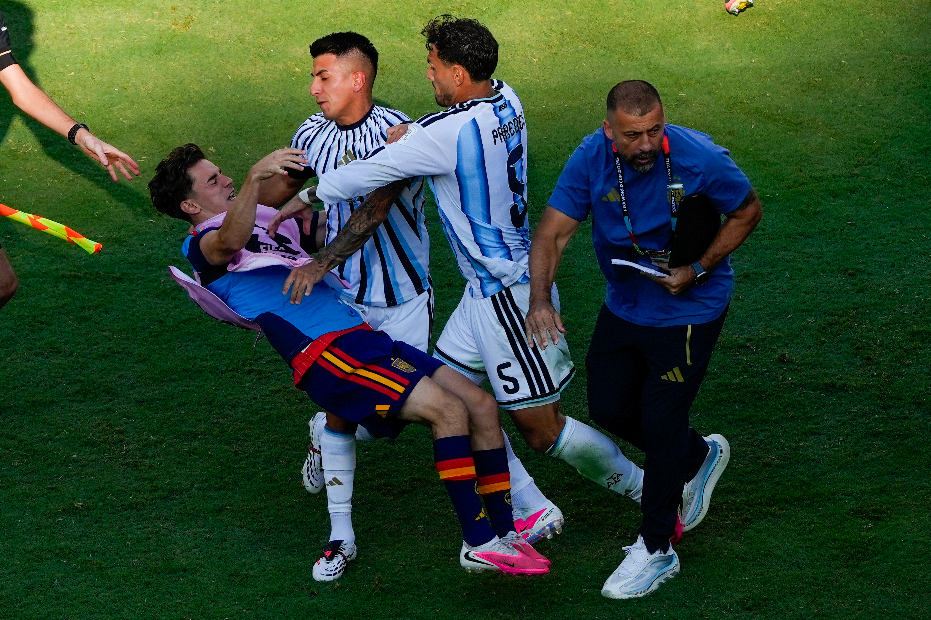 Spain's Gavi, left, falls as he scuffles with Argentina's Leandro Paredes (5) and Thiago Almada during the World Cup final match between Spain and Argentina.