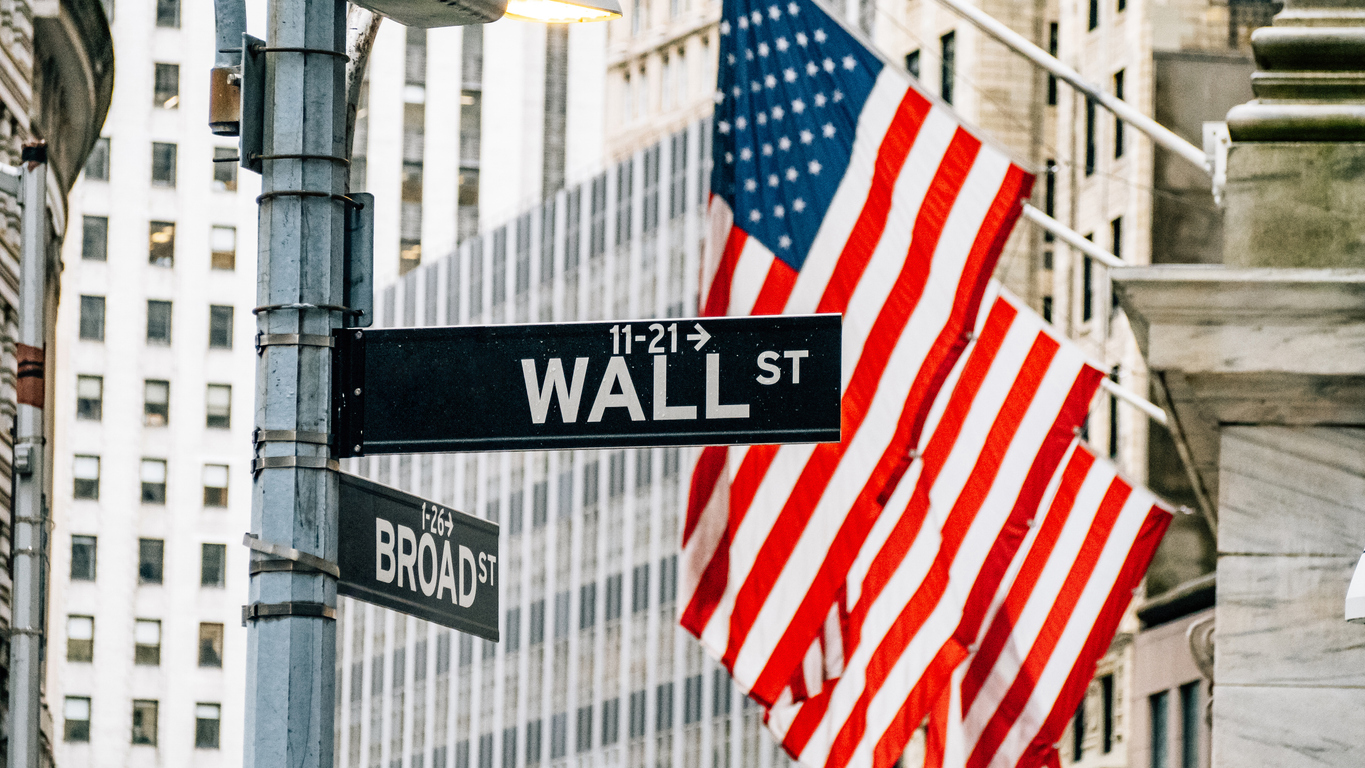 Wall street district in New York City with USA flags in the background stock photo.