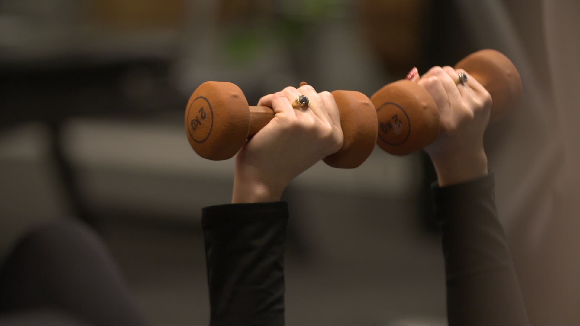 A person lifting weights as part of a cancer rehabilitation class.