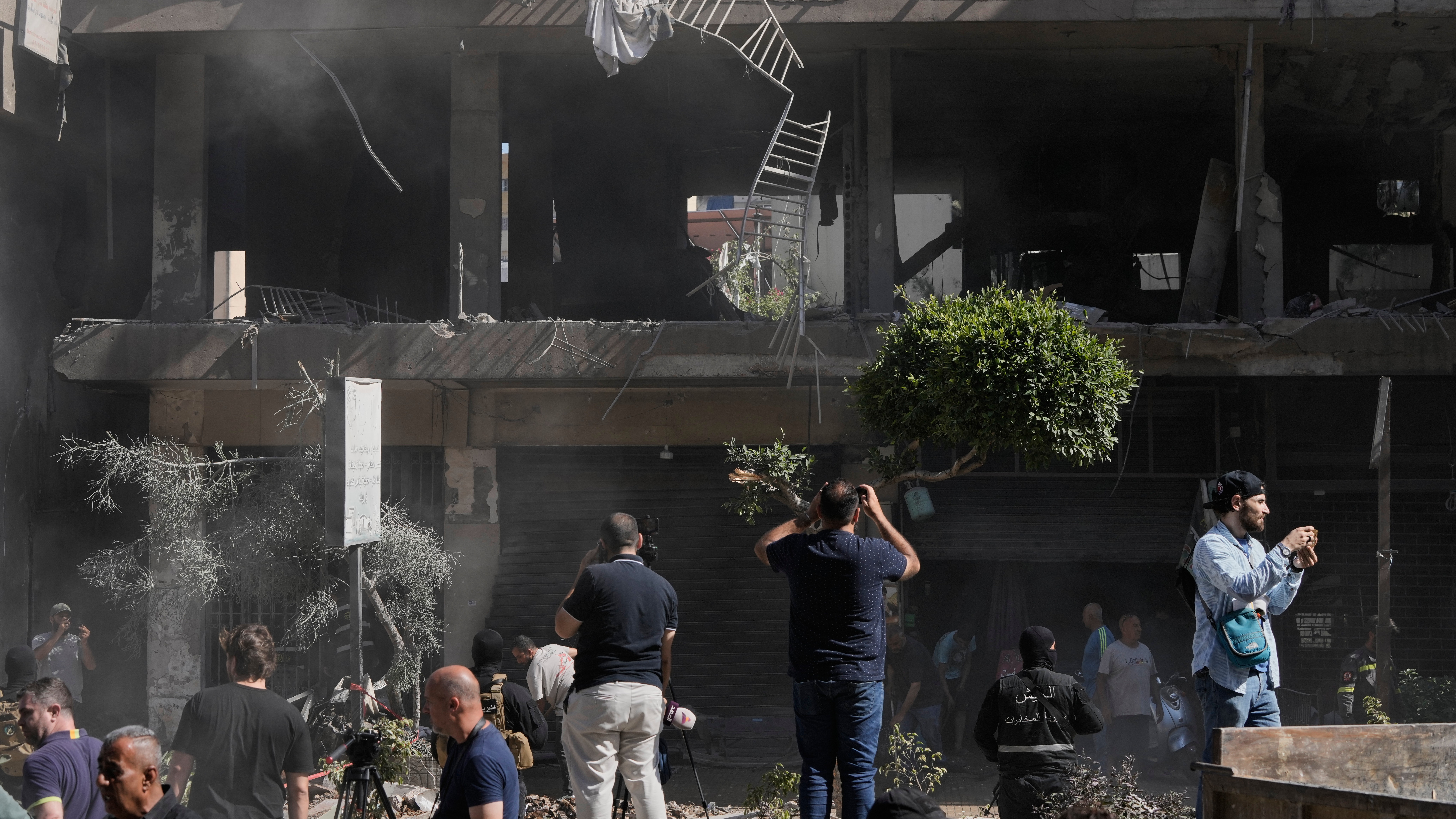 People gather at the site of an Israeli airstrike that struck an apartment in Dahiyeh, Beirut's southern suburbs, Lebanon.