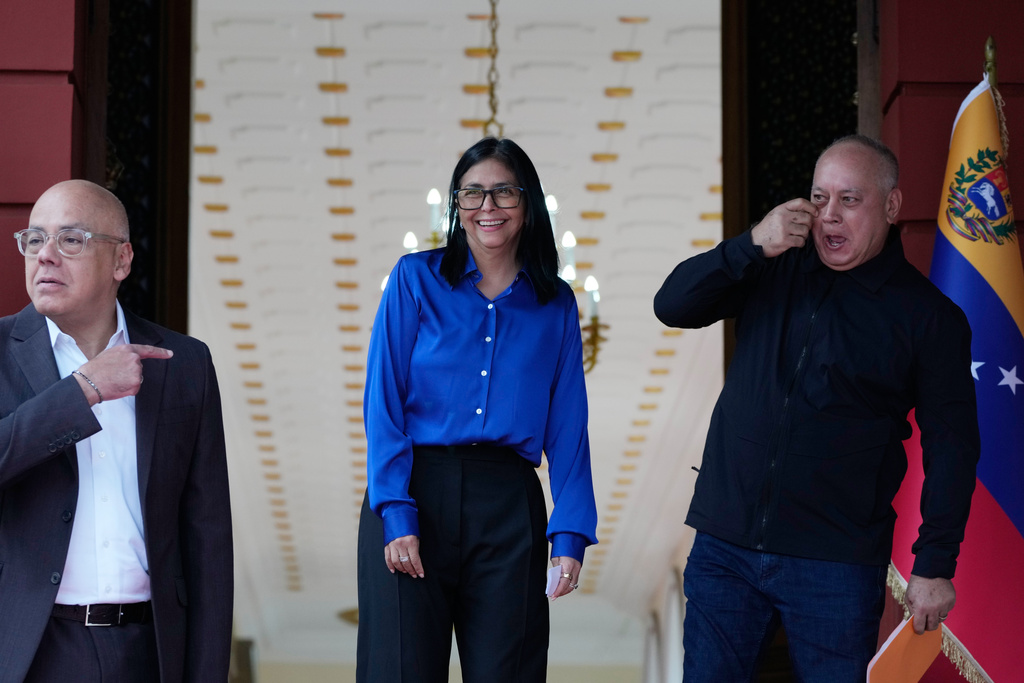 Venezuela's acting President Delcy Rodriguez, center, smiles flanked by Interior Minister Diosdado Cabello, right, and National Assembly President, her brother, Jorge Rodriguez