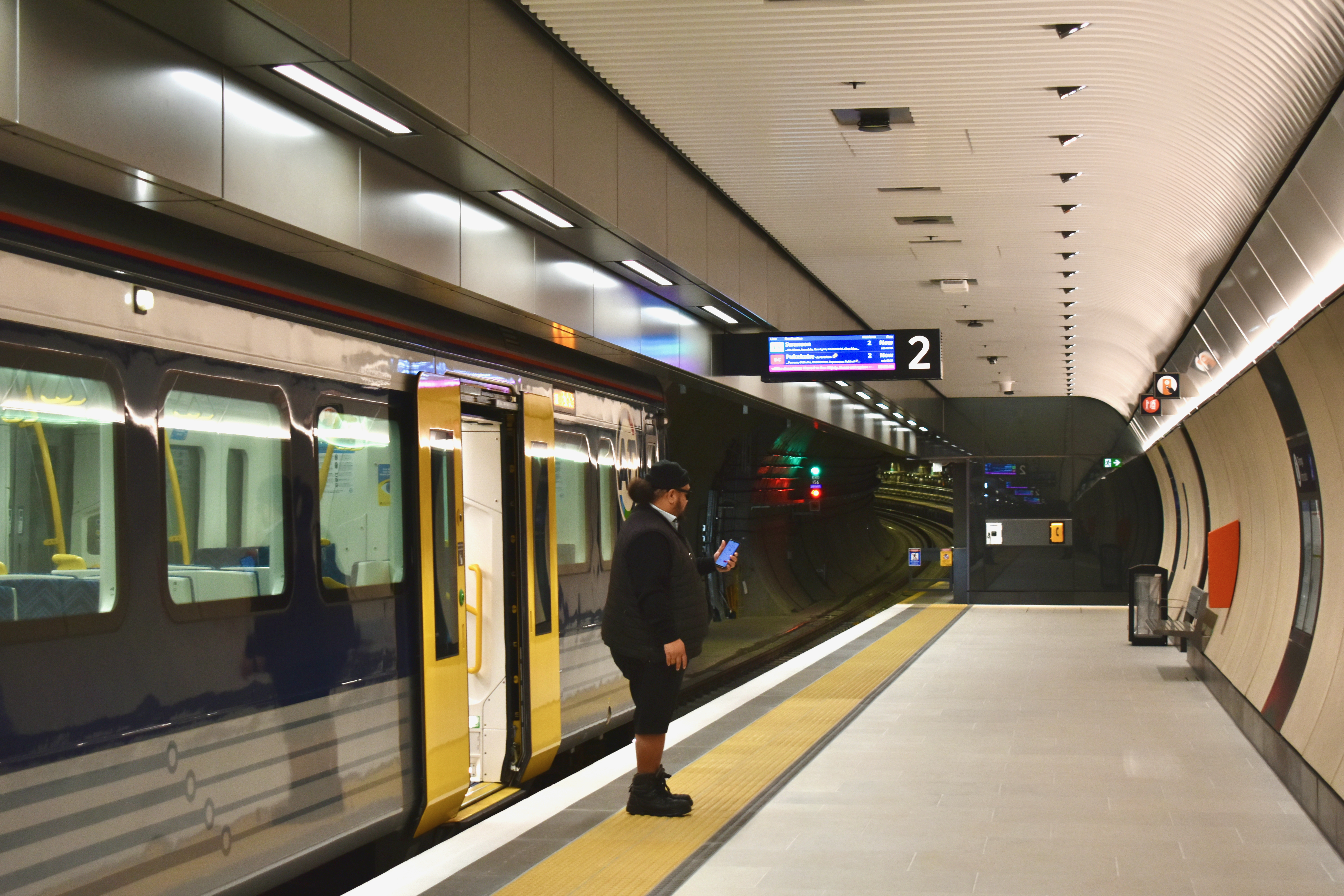 A train manager on the platform of Karanga-a-Hape station.