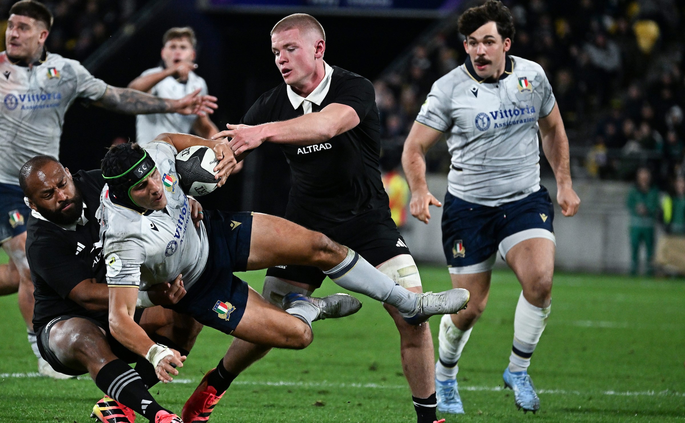 Anton Segner helps George Bower make a tackle against Italy.