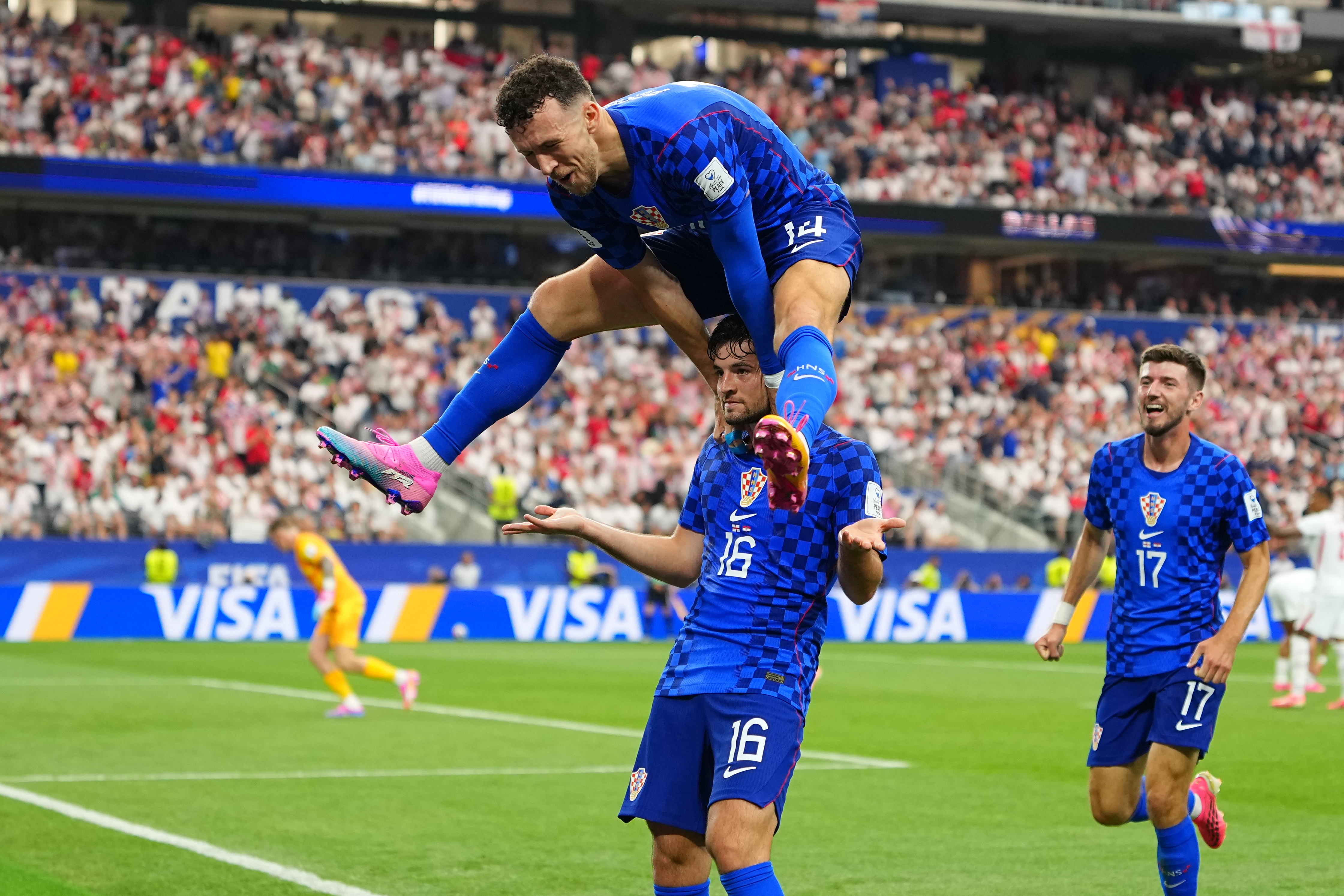 Croatia's Martin Baturina, bottom, is congratulated after scoring his side's first goal by Ivan Perisic after scored during the World Cup Group L match between England and Croatia in Arlington, Texas