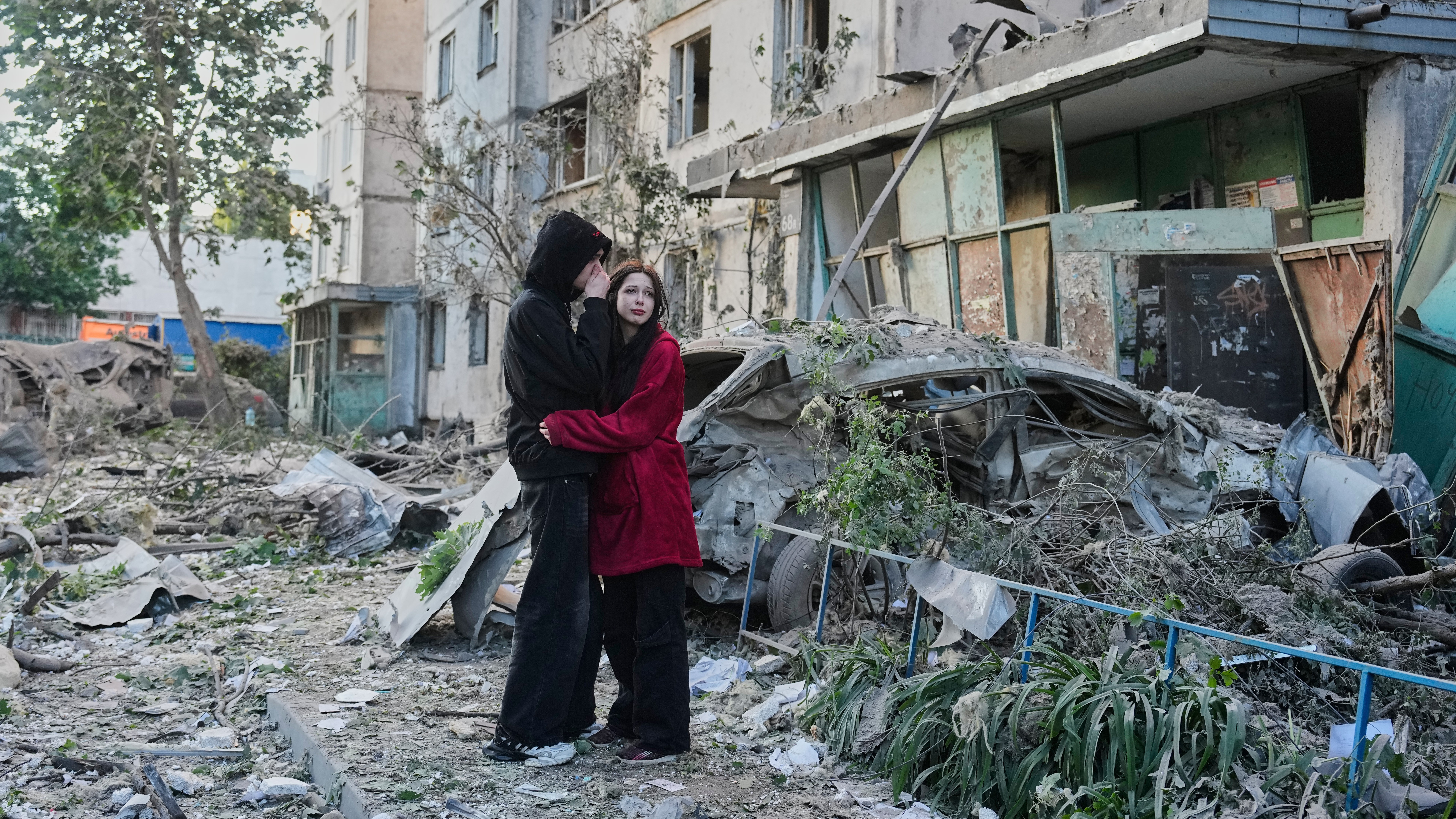 People react as they look at the site of Russian missile strike that hit a residential building in Kyiv, Ukraine, Tuesday, June 2, 2026.