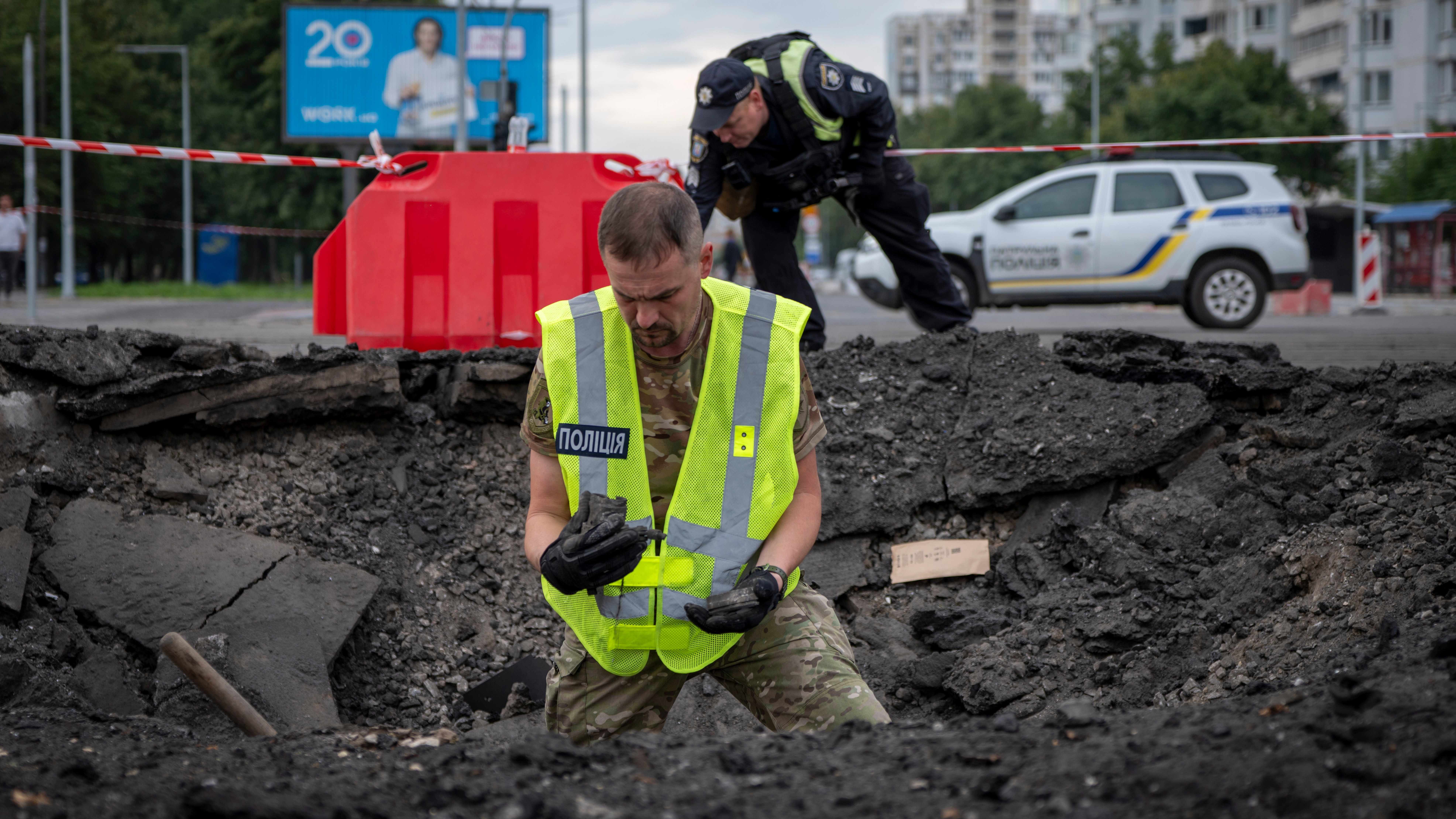 A sapper examines the impact site of a Russian missile in a residential area of Kyiv, Saturday, July 11, 2026. 
