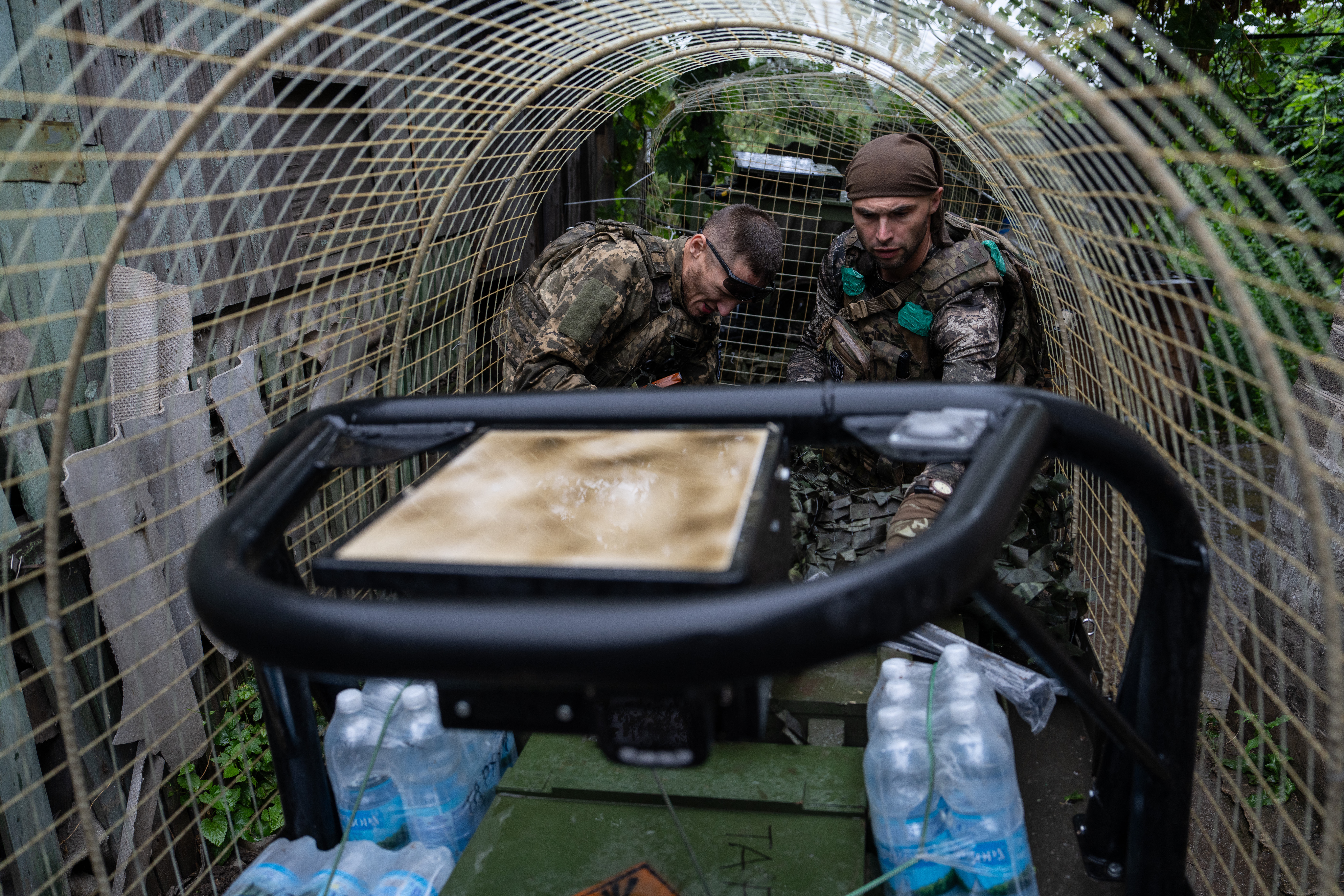 A Ukrainian serviceman unloads a ground drone that carries ammunition, water, and provisions in the frontline town of Druzhkivka, Donetsk region.