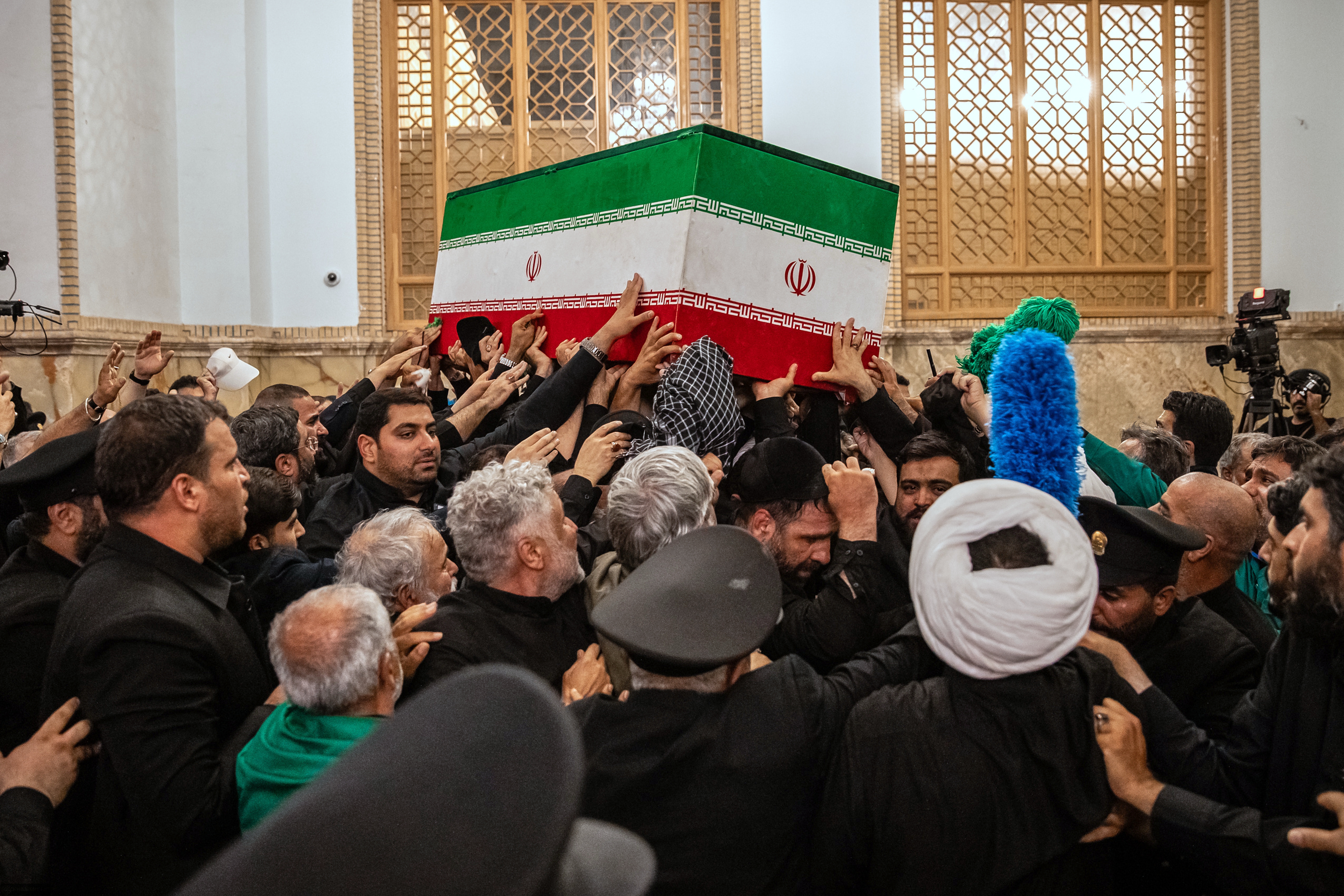 Mourners carry the coffin of the late Iranian Supreme Leader Ayatollah Ali Khamenei above the crowd for the final prayer before his burial at the Imam Reza Shrine in Mashhad.