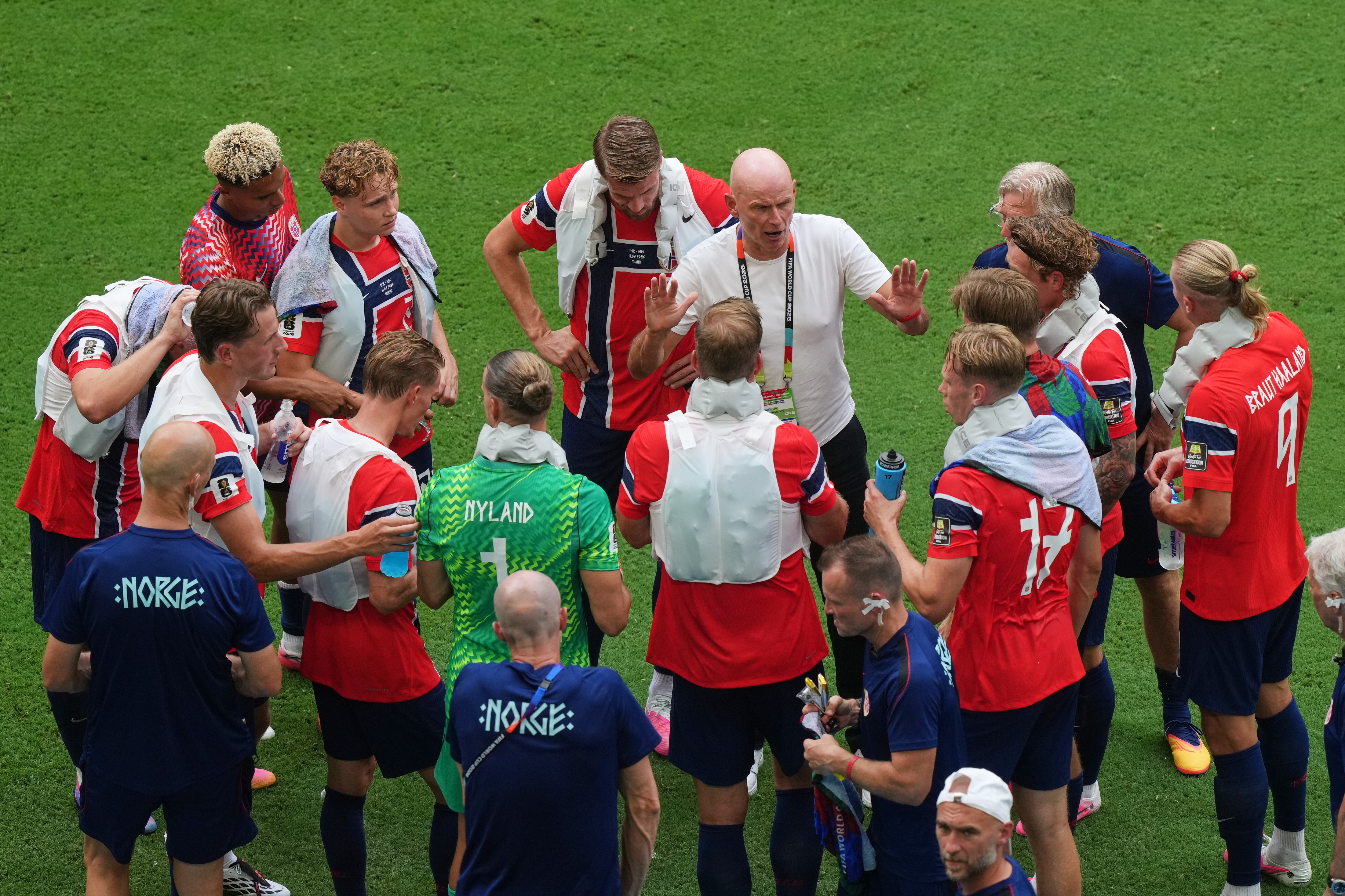 Norway head coach Stale Solbakken, in white shirt, talks to the team during a hydration break during the World Cup quarterfinal match between Norway and England. 