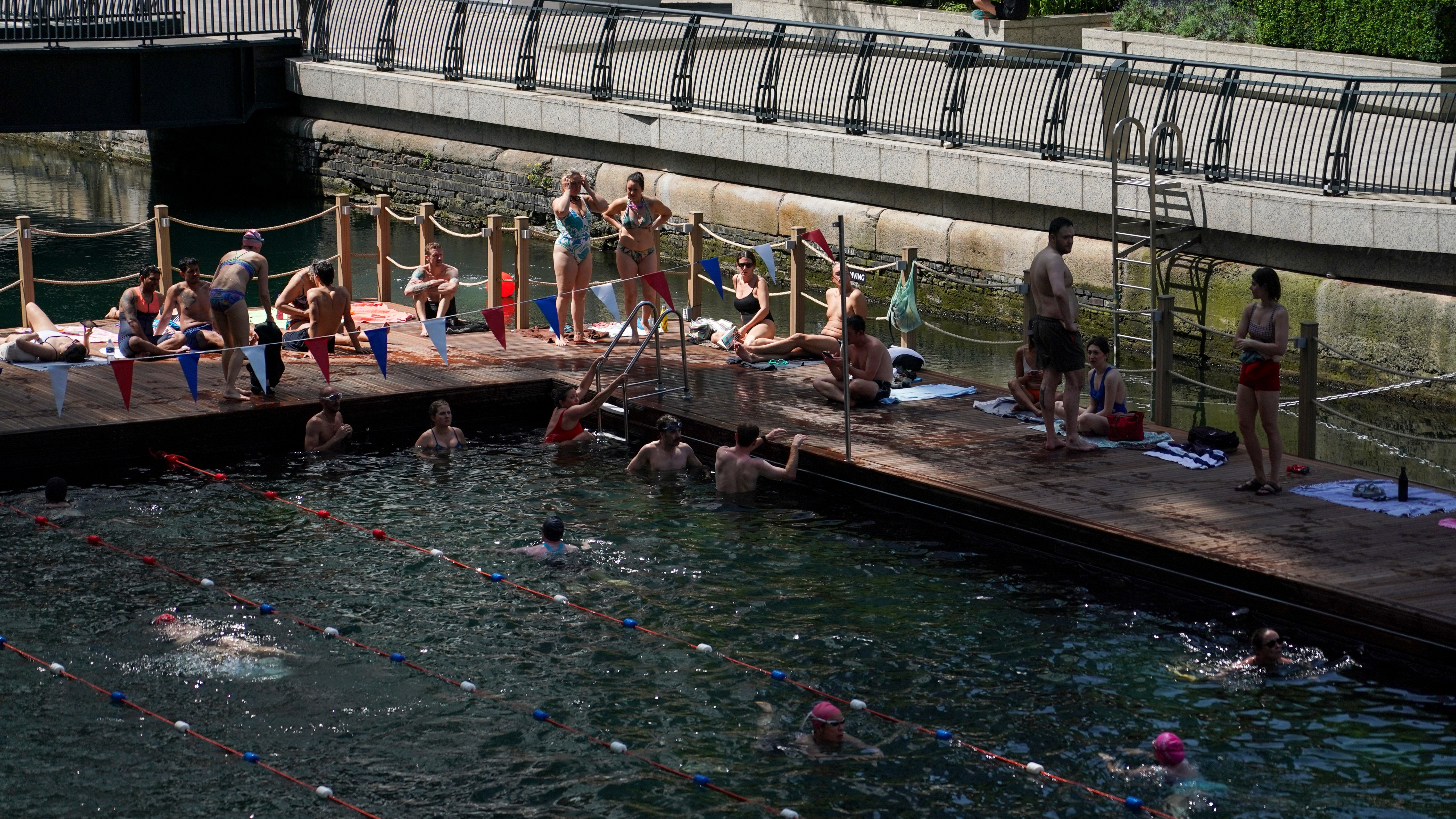 People swim in an outdoor swimming pool in London, Tuesday, June 23, 2026 as a heat wave is predicted across Britain.