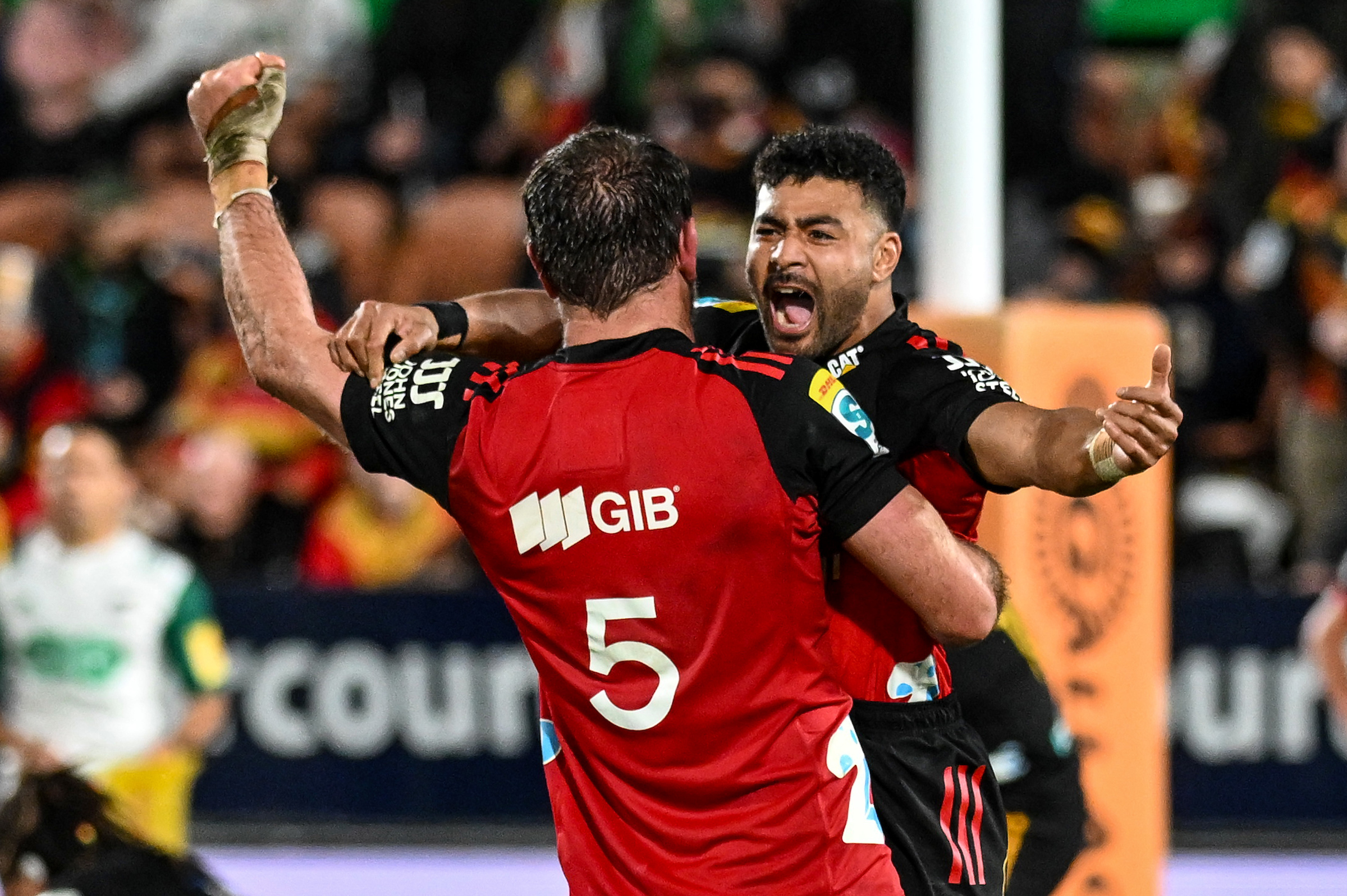 Richie Mo'unga leaps into Sam Whitelock's arms at the final whistle at Waikato Stadium.