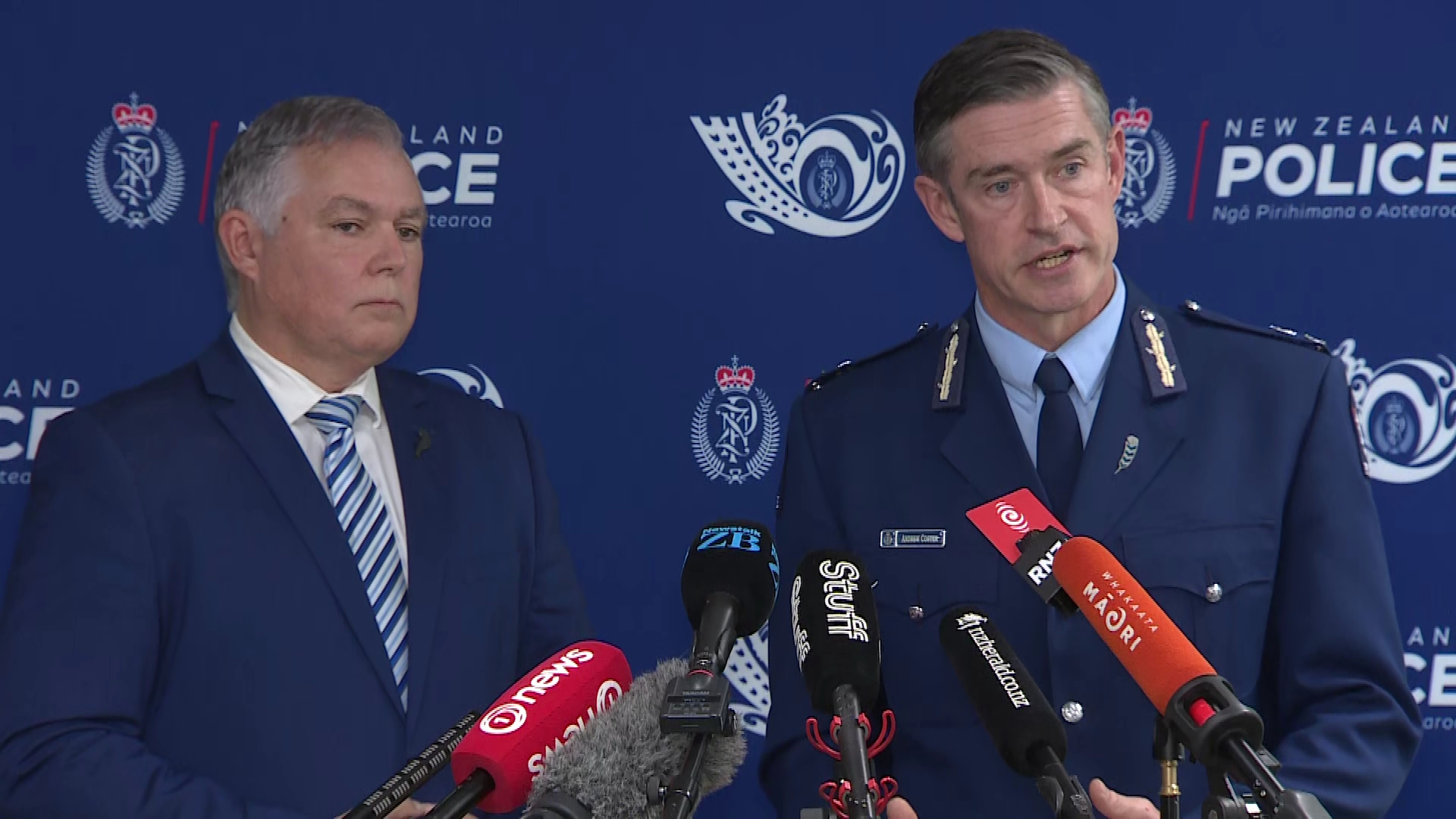 Police Commissioner Andrew Coster and Police Minister Mark Mitchell speak in Auckland. 