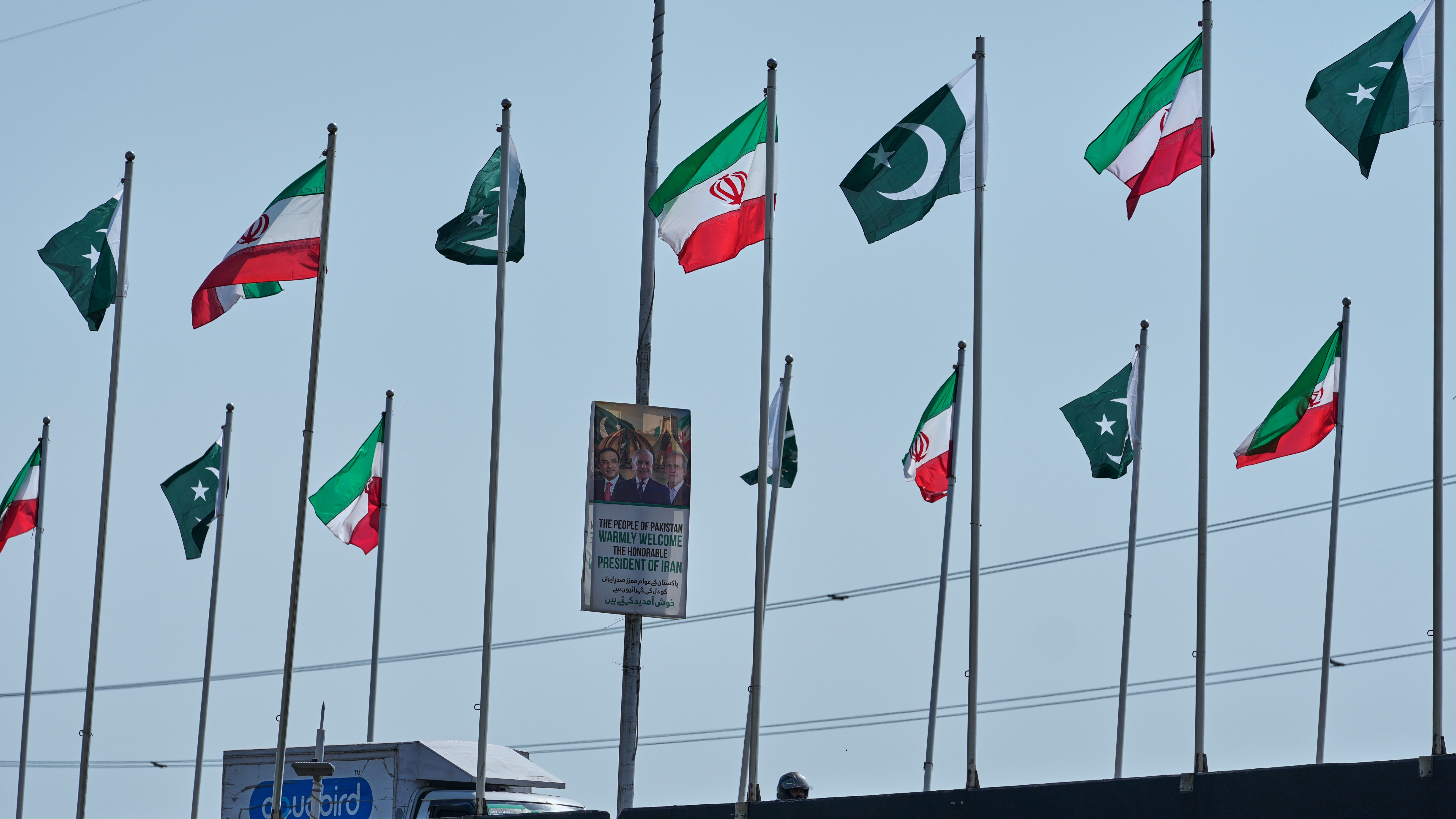 The welcoming billboard, featuring Iranian President Masoud Pezeshkian, right, with Pakistan President Asif Ali Zardari, center, and Prime Minister Shehbaz Sharif, is displayed alongside of an overhead bridge, in Islamabad, Pakistan.