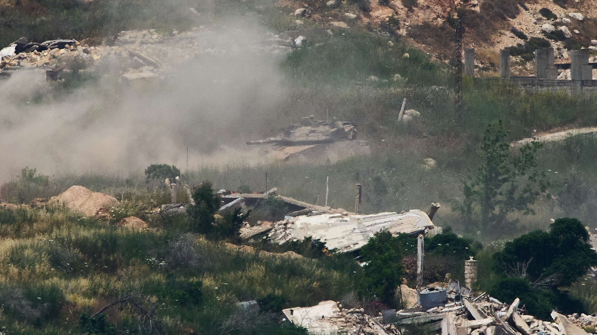 Israeli soldiers drive a tank in southern Lebanon as seen from northern Israel.