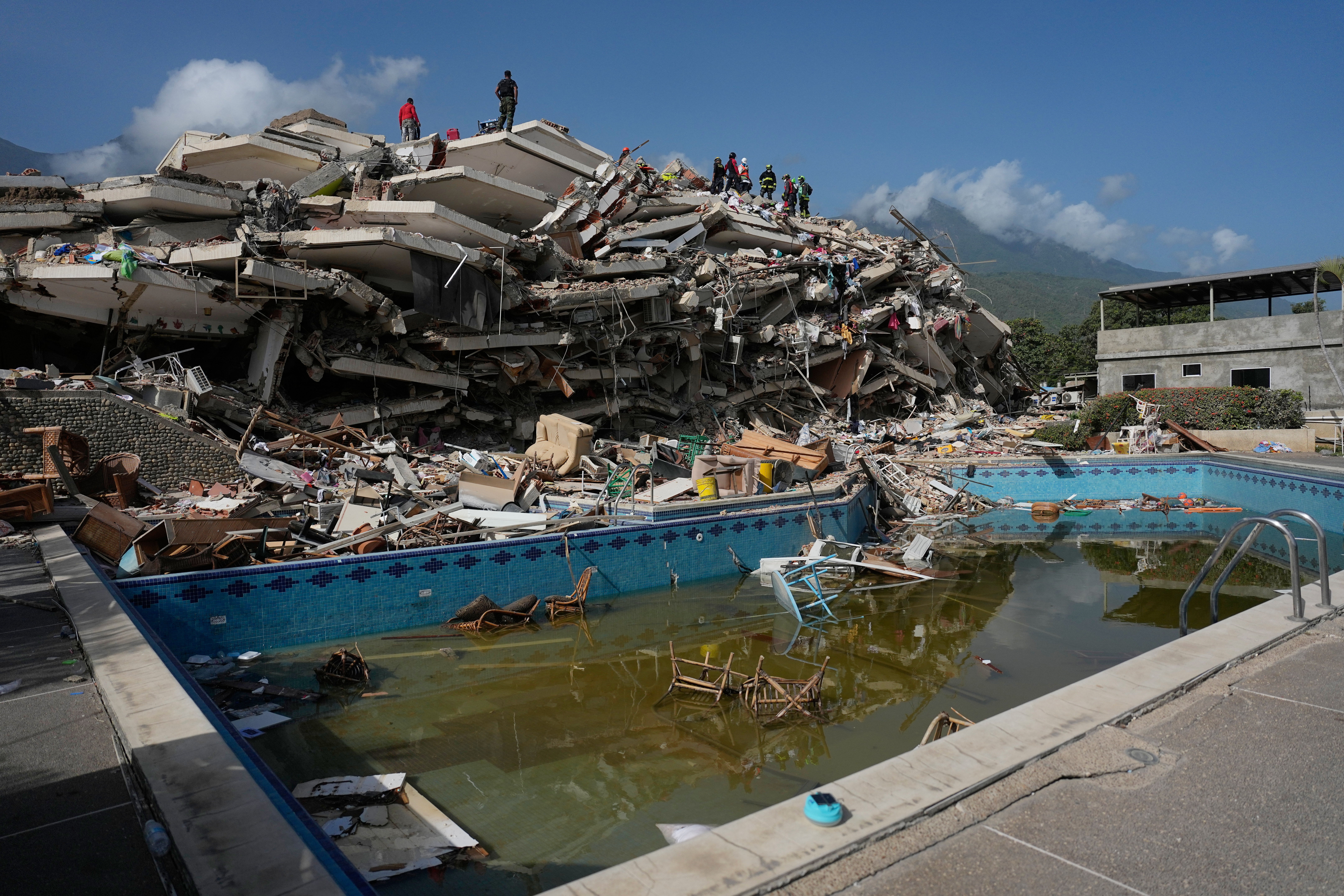 Rescue workers search through the rubble three days after earthquakes struck Catia La Mar, Venezuela